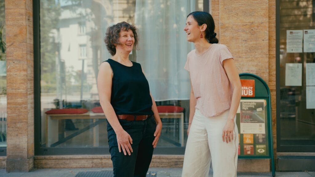 Maria und Paula stehen sich gegenüber und lachen ausgelassen.